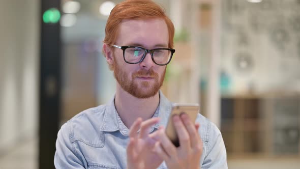 Portrait of Attractive Casual Redhead Man Using Smartphone 