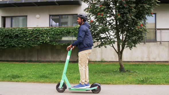 Man in Helmet Riding Electric Scooter on Street