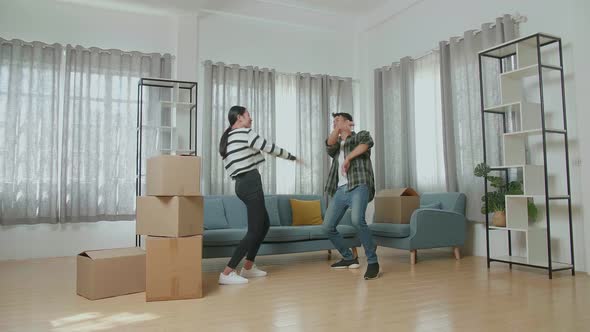 Happy Young Asian Couple Celebrating Finish Carrying Cardboard Boxes With Stuff Into A New House