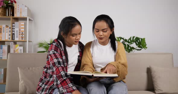Twin girls reading book together