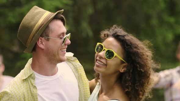 Flirty Young Man and Woman Hugging and Enjoying Dance Music at Summer Party