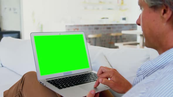 Man using laptop in living room at home 4k