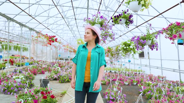 Sweet Girl Florist Walks in a Greenhouse with Flowers Carefully Examines Possessions Happy Smile