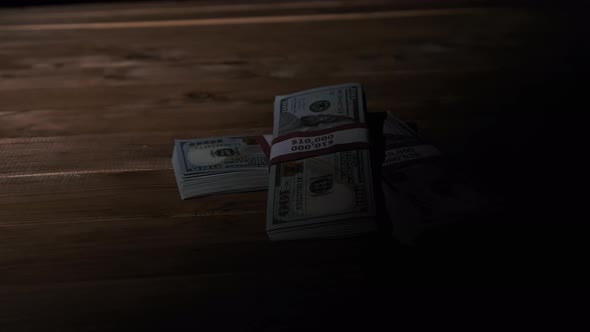 Three Stacks of 10000 American Dollars Banknotes in Bundles Lie on Wooden Table