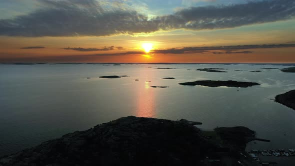 Vivid sunset at a rocky coastline with a marina and islands in the archipelago.