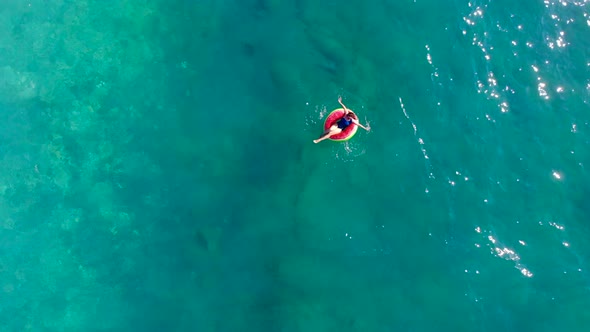 Woman Swims in Sea with a Rubber Ring.