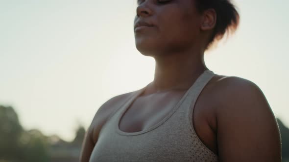 Woman practicing breathing exercise at the park in summer day. Shot with RED helium camera in 8K.