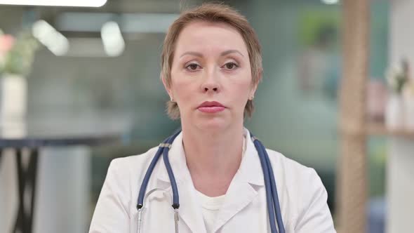 Serious Middle Aged Female Doctor Looking at the Camera