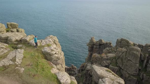 Man on top of a cliff in Cornwall enjoying the view