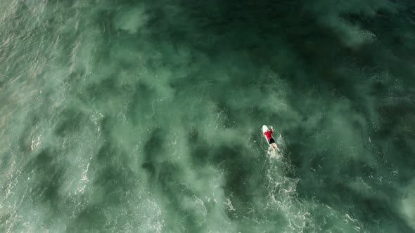 Top Down of Surfer Rowing on Waves