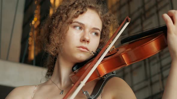 young curly blond woman the violinist: Musician playing violin