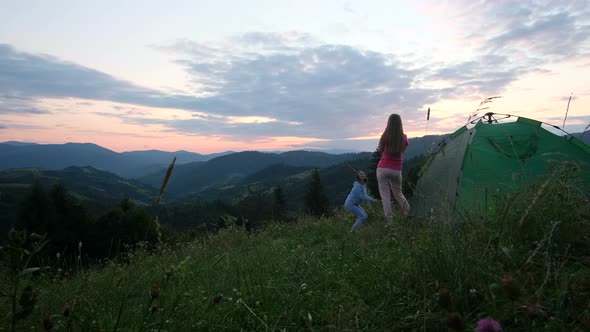 Girls Tourists are Photographed at Sunset in the Mountains They are Resting in a Green Tent