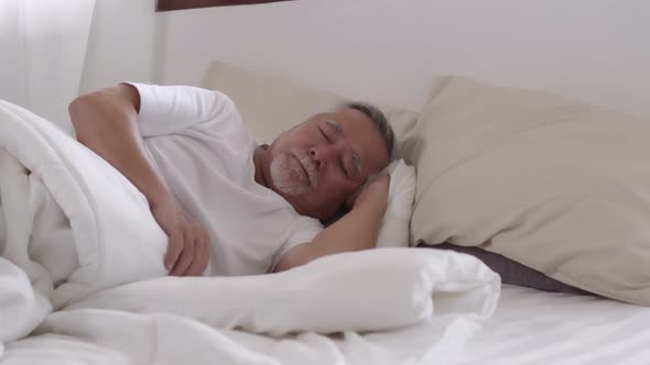 Asian Elderly man sleep and sweet dream on bed in bed room.