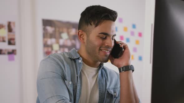 Mixed race man phoning in creative office