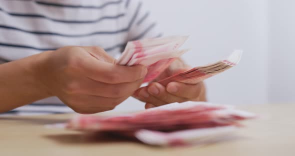 Man counting the number of RMB at home