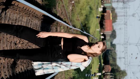 Vertical Young Sexy Woman Stands on the Train Tracks and Looks at the Camera