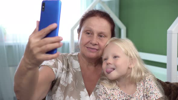 Happy Grandmother and Granddaughter Girl Take Selfie By Smartphone