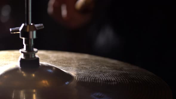 Hands of musician drummer holding drum sticks hitting on hi-hat cymbal