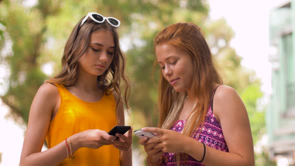 Teenage Girls with Smartphones in Summer Park