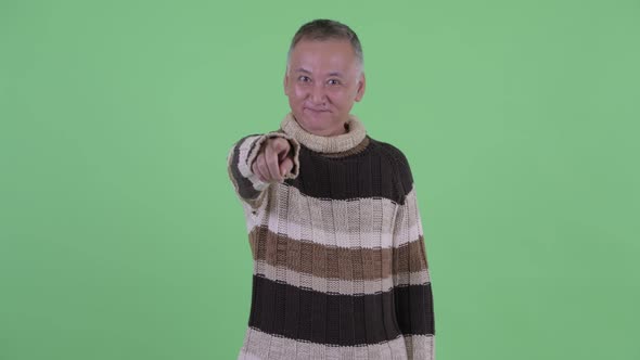 Happy Mature Japanese Man Pointing at Camera Ready for Winter