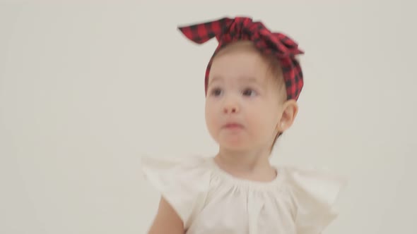 Little Girl in Plaid Headband is Eating Banana