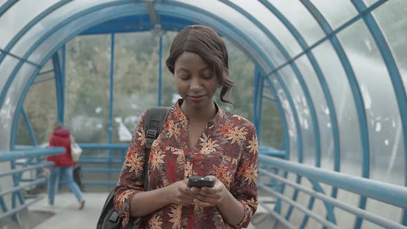 Cute African American Girl Texting on Phone Attended on Screen of Tablet, Afro Female, Beautiful