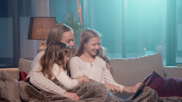 Mother with Daughters Using Laptop for Video Call at Home