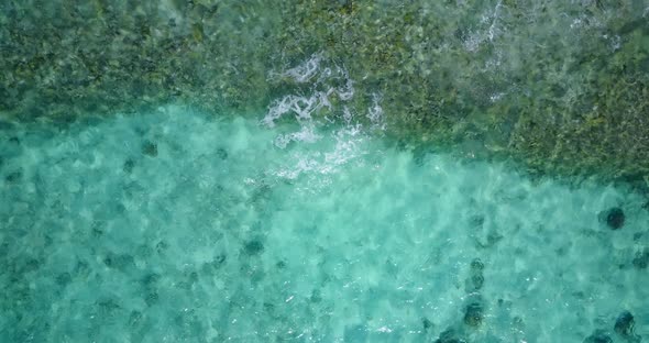 Tropical birds eye island view of a white sandy paradise beach and blue ocean background in vibrant 