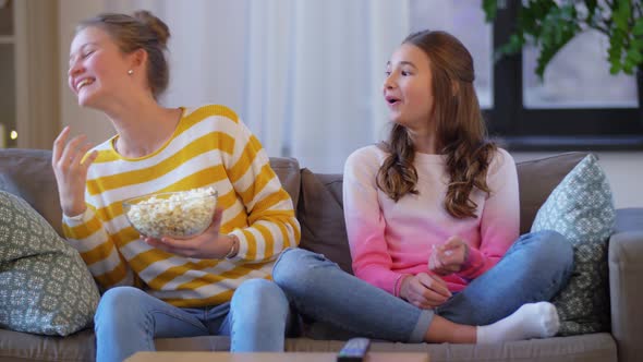 Teenage Girls Eating Popcorn at Home