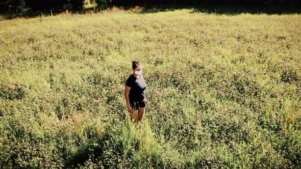 Weird Dream Nightmare Woman Standing Alone in a Flower Field with Medical Mask Aerial Shot