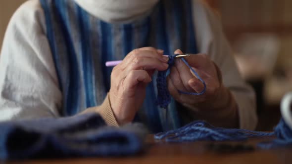 A woman knitting a neck warmer