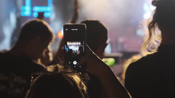 Woman Hand with Smartphone Making Video at Live Rock Concert. Slow Motion