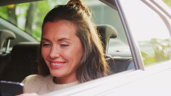 Woman in Car Using Smartphone