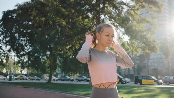 Young Athletic Female Runner Put on Headphones Start Marathone Training