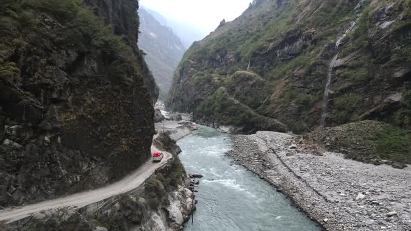 Vehicles driving on narrow cliff road along the Marsyangdi River