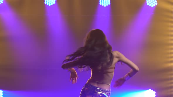 Girl in a Green Shiny Oriental Costume Performs Classical Belly Dance, Shot in a Dark Studio 