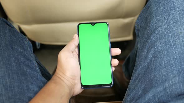 Hand Holding Smart Phone with Empty Screen in a Car