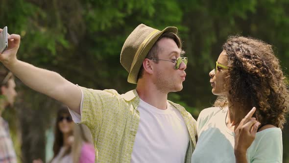 Young Woman and Man Having Fun, Taking Selfies at Summer Music Festival