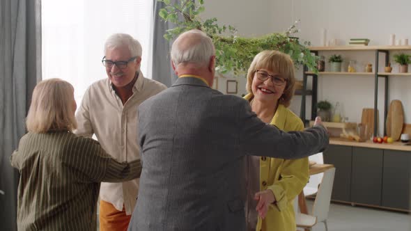 Happy Senior Couple Greeting Guests at Home