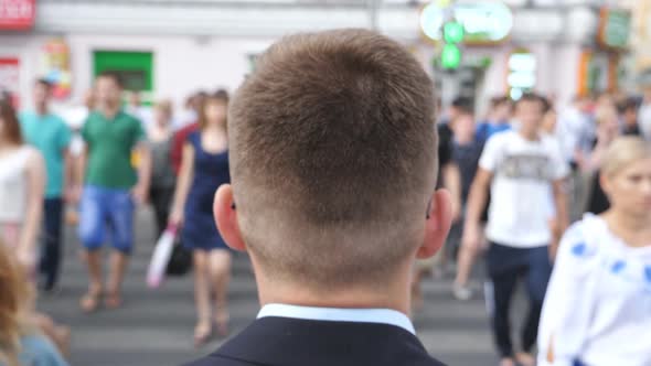 Rear View of Young Businessman in Black Suit Crossing the Road in Downtown. Confident Entrepreneur