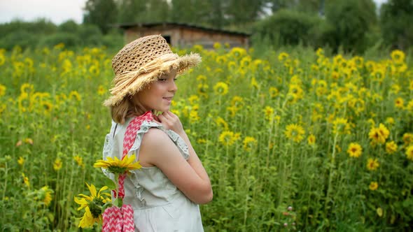 Beautiful Smiling Girl in Wicker Hat Posing on Sunflower Field
