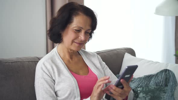 Happy American Woman Holding Phone in Hand, Communication Online in Apartment Room