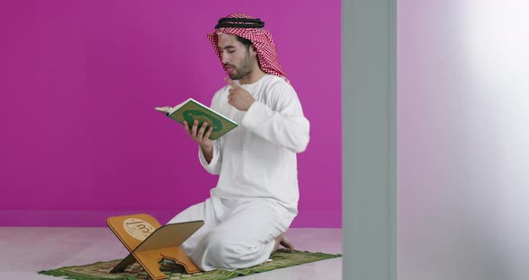 Arabian Muslim Man in Traditional Clothes Praying During a Ramadan Feast at Home