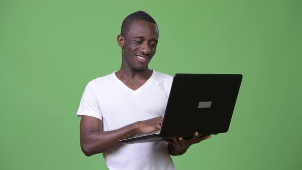 Young Happy African Man Smiling While Using Laptop