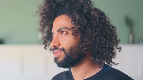 Closeup Young Arabian Man with Black Curly Hair Smiling Turns Head