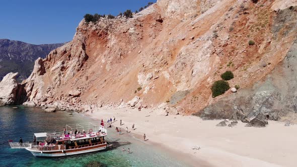 Drone Shooting of Tourists on a White Sandy Beach Surrounded By Volcanic Rocks of the Island of