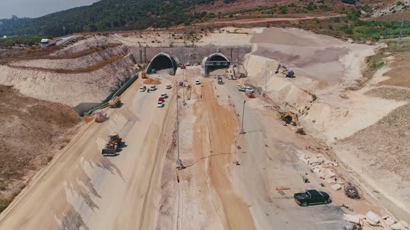 Aerial footage of large highway construction project with tunnels and bridges