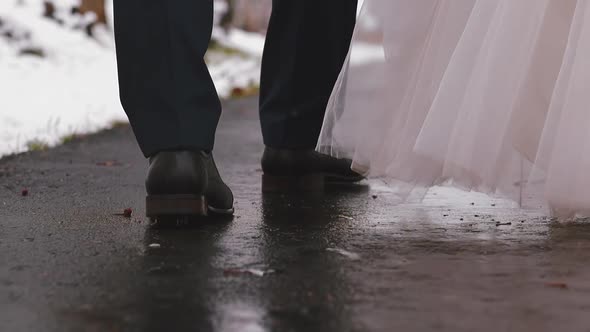 Man and Woman in Festive Clothes Walk Along Empty Wet Road