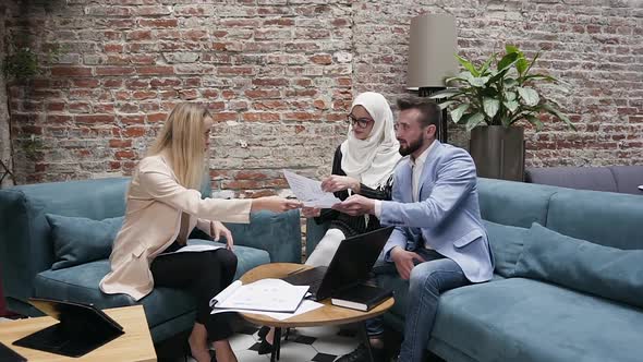 Three of Successful Mixed Race Male and Female Office Managers Working with Financial Reports