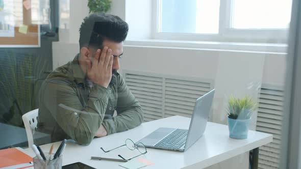 Tired Middle Eastern Businessman Working with Computer and Touching Head Feeling Stressed and